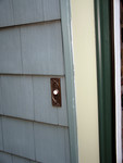gouges in siding near most visible spot - doorbell